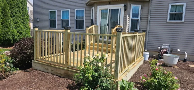 Pressure-treated wood deck with spindle railing and solar post caps, Northern Indiana deck installation