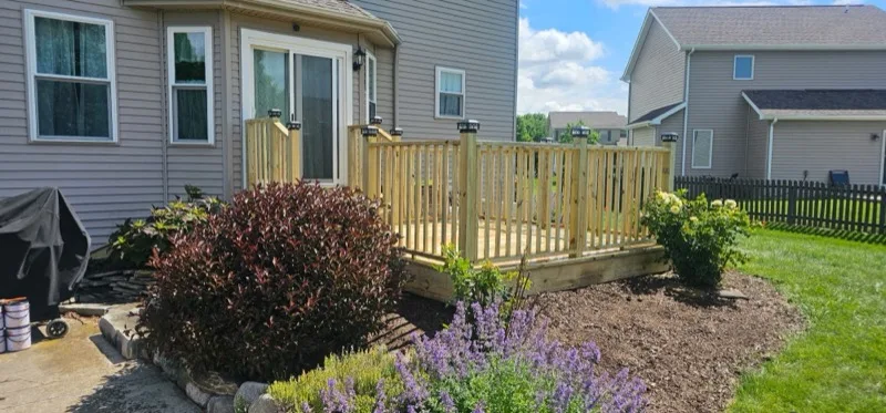 Wood deck with spindle railing and solar post caps, backyard view, Northern Indiana